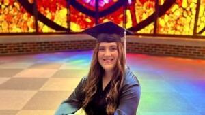 兰妮·伯勒森戴着毕业帽坐在洛格斯登教堂里.